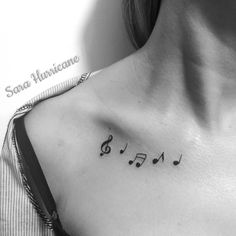 a woman's chest with musical notes tattooed on her left side ribcage