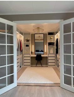 an open door leading to a dressing room with mirrored doors and drawers on both sides