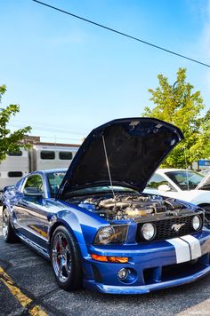 a blue mustang car with its hood open