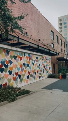 a wall with hearts painted on it in front of a building near a fire hydrant