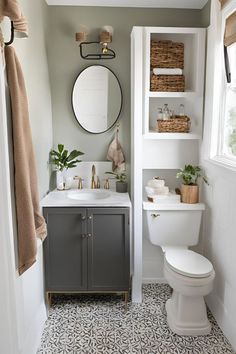 a white toilet sitting next to a bathroom sink under a round mirror in a bathroom