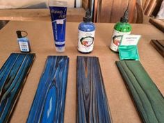 several different types of wood sitting on top of a table next to bottles and glue