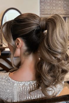 This charming ponytail showcases a lush trail of curls, adding a stylish twist to the classic updo. The hair is securely pulled back and fastened at mid-height, allowing the voluminous curls to flow gracefully, exuding a sense of timeless charm. It's an excellent choice for those seeking a quick hairstyle that seamlessly - Click to see more of Effortless and Elegant: 28 Time-Saving Ponytail Styles for Busy Days and follow us for more hairstyle ideas. // Photo Credit: Instagram @archanarautela Ponytails With Bangs, Ponytail Inspiration, Prom Ponytail Hairstyles, Fancy Ponytail, Bridal Ponytail, Voluminous Ponytail, Chic Ponytail, Quick Hairstyle, Hair Tricks