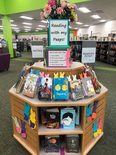 there is a book stand with many books on it in the middle of a library