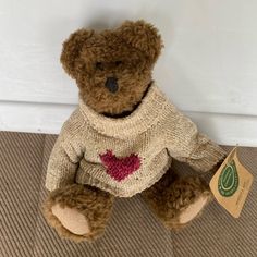 a brown teddy bear wearing a sweater with a red heart on it's chest