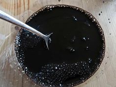 a spoon in a bowl filled with black liquid