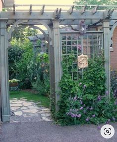 an outdoor garden with vines and flowers growing on the walls, along with a stone walkway