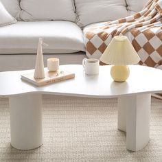 a white coffee table sitting on top of a carpeted floor next to a couch