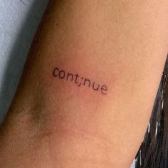 a woman's arm with the word continue written in cursive font on it