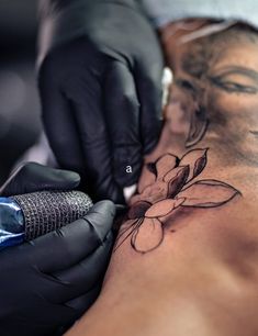 a person getting a tattoo done on their arm and shoulder with black gloves around them