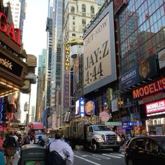 a busy city street filled with lots of traffic and people walking on the side of it