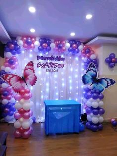 balloon arch with butterfly decorations and blue trash can in front of the entrance to an event