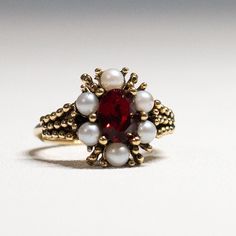 A Vintage 1973 Avon "ROSEGLOW" CLUSTER RING with a Gold Tone Finish and Faux Ruby / Garnet and Pearls -  Rings have "Adjustable Sizes": Medium - 5.5 to 7. This 51-year-old item is in very good condition Vintage Red Birthstone Rings, Vintage Red Ring For Anniversary, Vintage Red Cluster Ring For Wedding, Vintage Red Ruby Birthstone Ring, Vintage Red Birthstone Promise Ring, Red Vintage Birthstone Promise Ring, Victorian Red Cluster Ring For Anniversary, Vintage Red Ruby Ring Birthstone, Vintage Red Ruby Ring With Birthstone