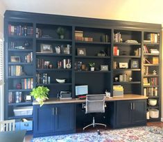 a home office with black bookcases and an area rug