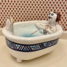 a ceramic bathtub with a figurine in it