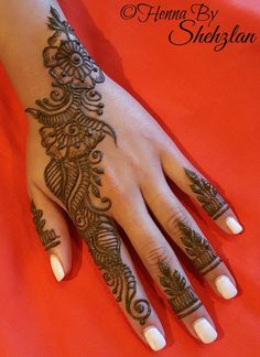 a woman's hand with henna tattoos on it