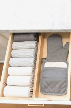 an open drawer with towels and other items in it