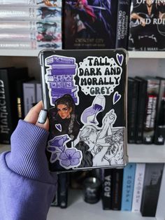 a person holding up a book in front of bookshelves