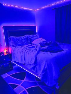 a bed in a room with purple lights on the walls and carpeted flooring