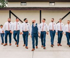 a group of men standing next to each other in front of a building wearing ties