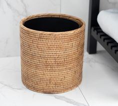 a basket sitting on top of a white counter next to a black chair and ottoman