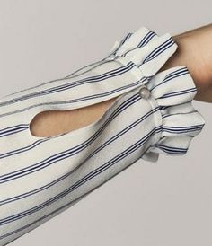 a woman's arm with a white and blue striped shirt on it