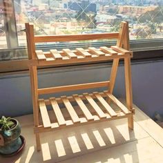 a wooden chair sitting on top of a window sill next to a potted plant