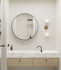 a bathroom with two sinks and a large round mirror above the sink in front of it