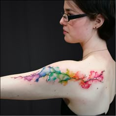 a woman with her arm painted with watercolors and the words shell shock tattoos