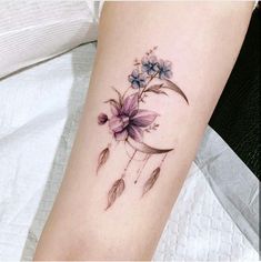 a woman's arm with a flower tattoo on it