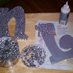 the letters are made out of silver glitters and plastic bottles with glue on them