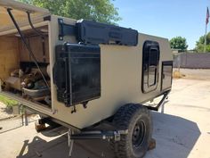 an off - road camper is parked in the driveway