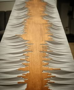 an intricately designed wooden table with white paper on it's sides and wood grained edges