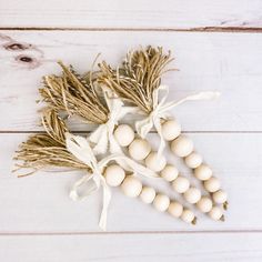 an arrangement of white beads and dried herbs on a wooden background with space for text