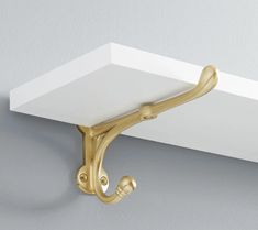 a white shelf with a gold handle on it