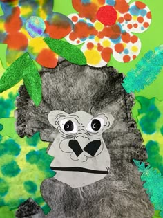 an animal made out of paper with flowers on it's head and leaves in the background