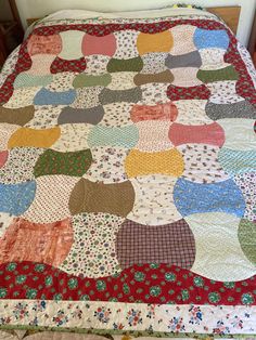 a bed with a colorful quilt on top of it