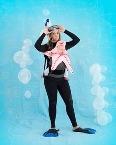 a woman holding a starfish in front of her face while wearing scuba gear and snorkels