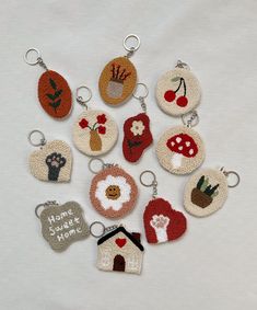 a bunch of different key chains that are made to look like small houses and flowers