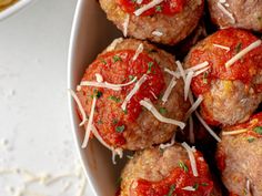 meatballs covered in marinara sauce and parmesan cheese