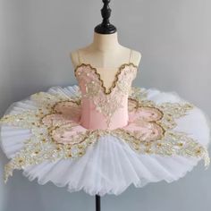 a white and pink ballet dress on a mannequin dummy with gold sequins