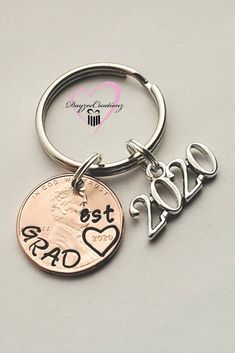 a penny keychain with the word dad on it and a heart charm attached to it