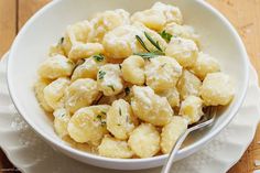 a white bowl filled with macaroni and cheese on top of a wooden table