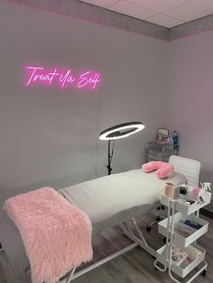 a pink neon sign above a bed in a room