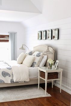 a bedroom with white walls and wood floors