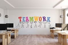 an office with two desks and three computer screens on the wall that say teamwork