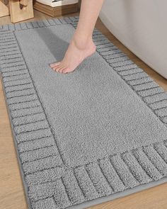 a person standing on top of a gray rug