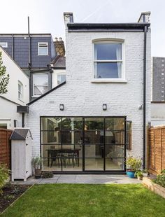 a white brick house with glass doors and windows