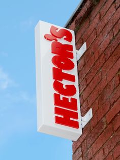 a red and white sign on the side of a brick building