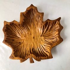 a wooden leaf shaped object on a white surface